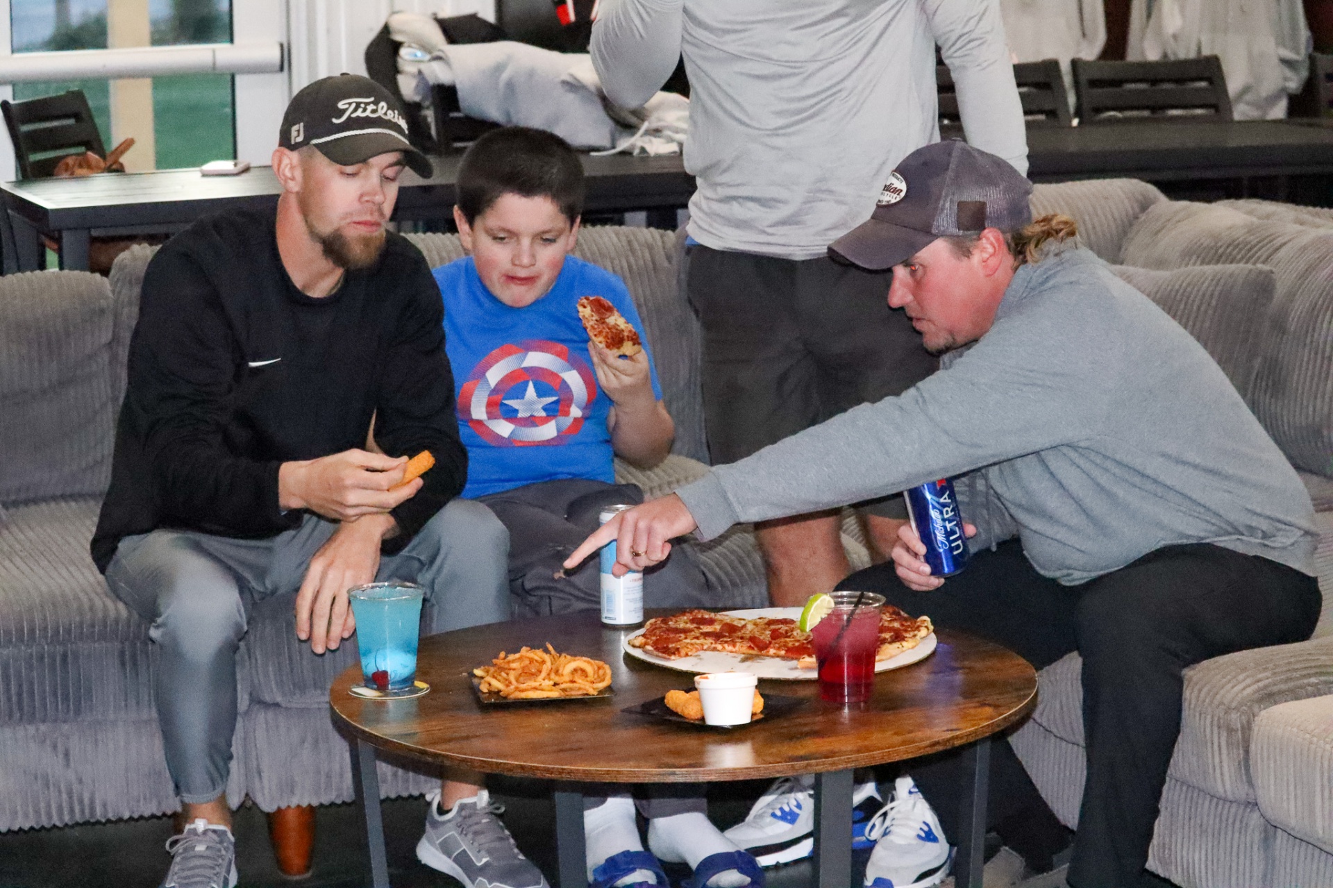 Guests relaxing with pizza and drinks during a group bay rental at The Flight Zone