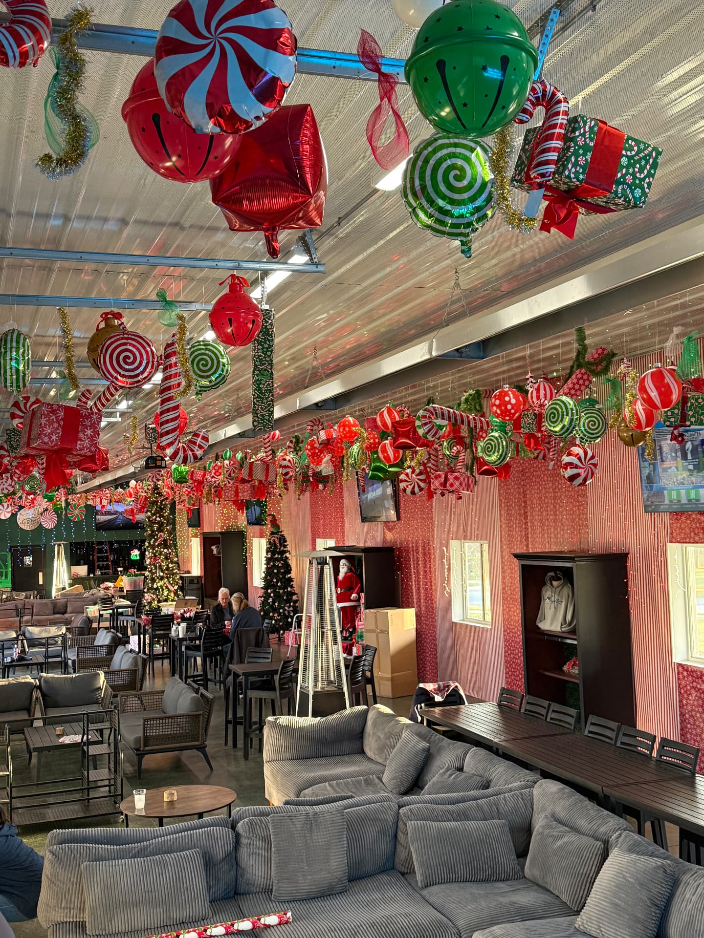 The Flight Zone lounge and bays covered in giant Christmas ornaments, balloons, and lights